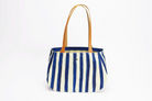 Vue de face sac cabas fourre-tout en toile et cuir - Rayé bleu et blanc. Anse en cuir marron.