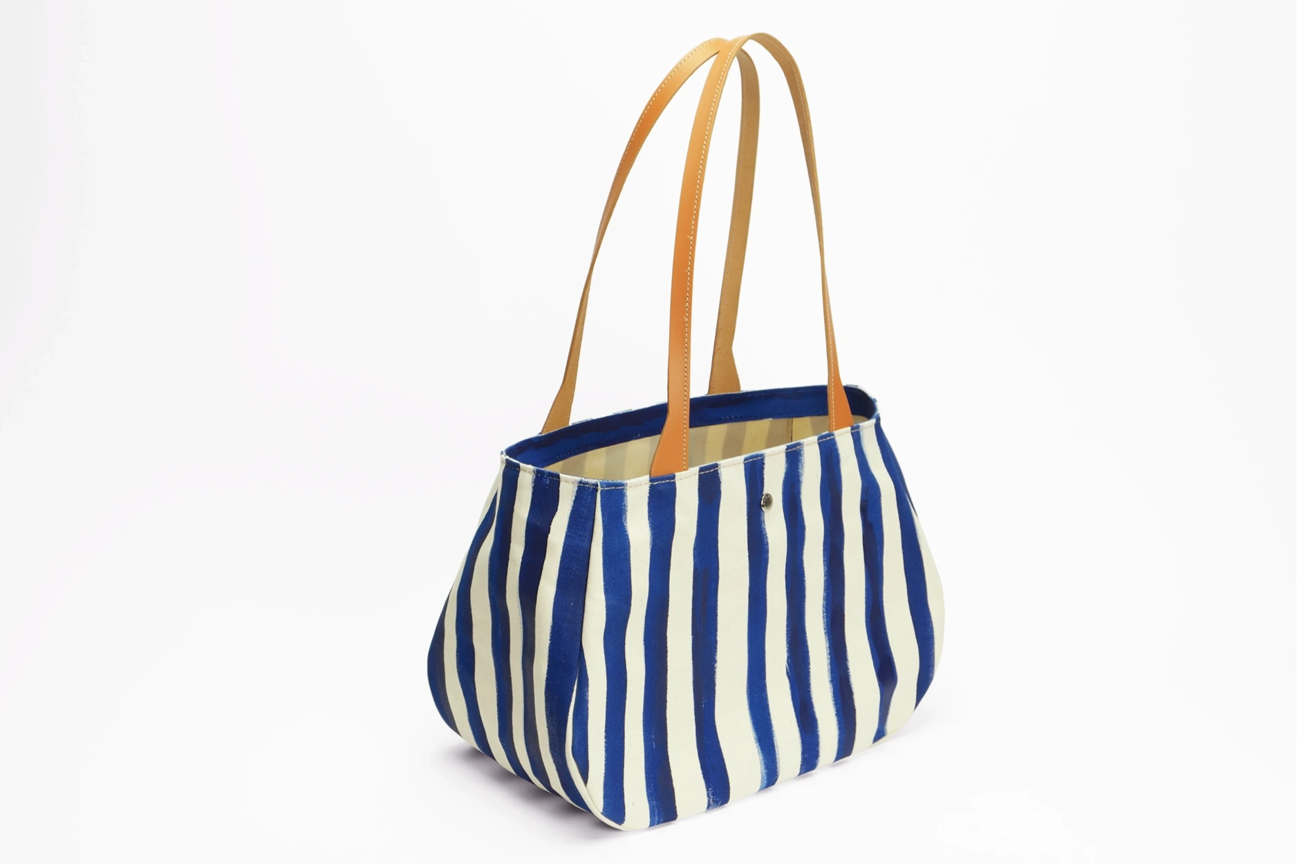 Vue de côté sac cabas fourre-tout en toile et cuir - Rayé bleu et blanc. Anse en cuir marron.